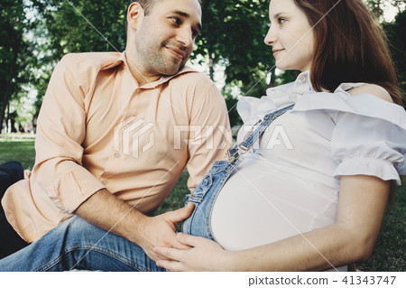 Mother and father hands hugging pregnant belly 41343747