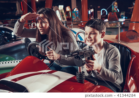 Smiling mother and son sitting on toy car Smiling mother and son sitting on toy car 41344284