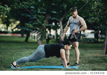 Overweight woman working out with trainer support Overweight woman working out with trainer support 41344338