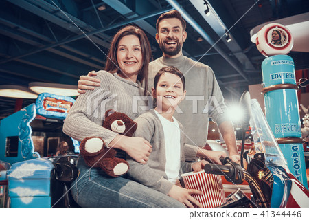 Happy family sitting on toy motorbike Happy family sitting on toy motorbike 41344446