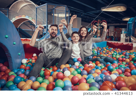 Glad family sitting in pool with balls 41344613