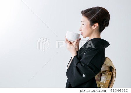 A woman in black drinking sleeping drinking green tea A woman in black drinking sleeping drinking green tea 41344912