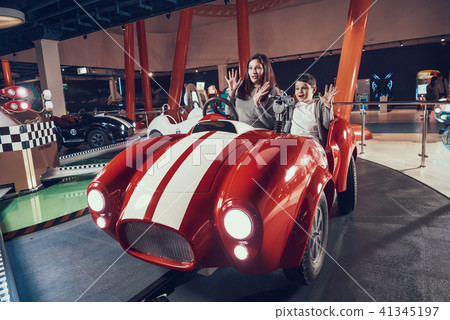 Wondered mother and son sitting on toy car Wondered mother and son sitting on toy car 41345197