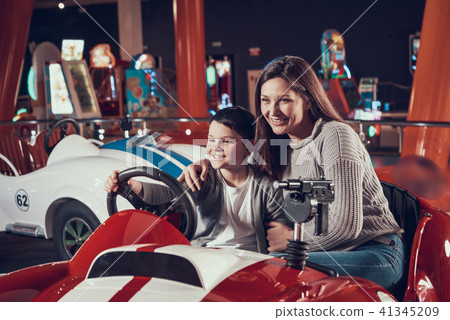 Happy smiling mother and son sitting on toy car Happy smiling mother and son sitting on toy car 41345209
