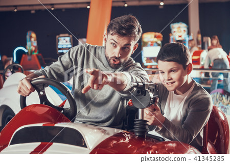 Joyfull father and son sitting on toy car 41345285