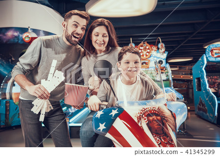 Happy family sitting on toy motorbike Happy family sitting on toy motorbike 41345299