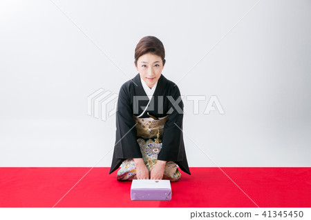 A woman in black dressing that hands a gift A woman in black dressing that hands a gift 41345450