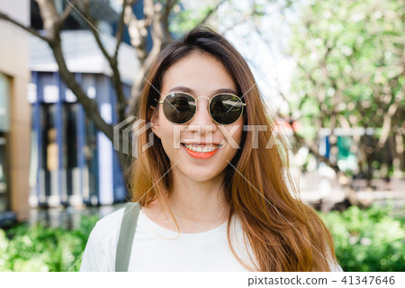 Asian woman smile in the garden enjoying her city. Asian woman smile in the garden enjoying her city. 41347646