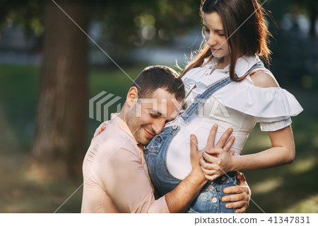 Father expecting for baby hugging his wife belly Father expecting for baby hugging his wife belly 41347831