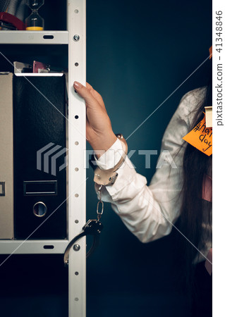 Womans hand handcuffed to metal rack. 41348846