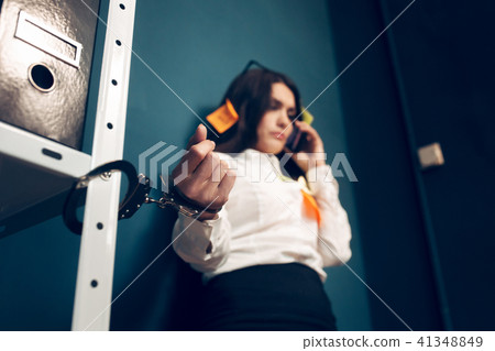 Woman handcuffed to metal rack. 41348849