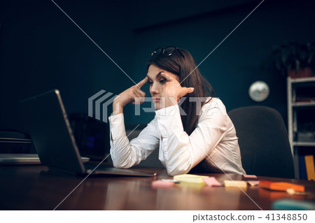 Woman trying to keep her eyes open while working. Woman trying to keep her eyes open while working. 41348850