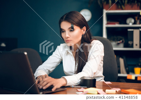 Woman trying to keep her eyes open while working. 41348858