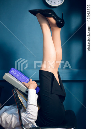 Lady lying on chair in unusual position reading book. Lady lying on chair in unusual position reading book. 41348891