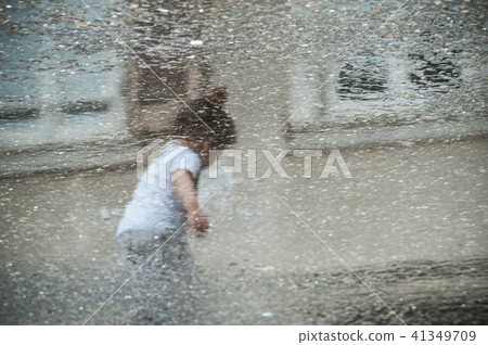 reflection of child playing with water in fountain 41349709