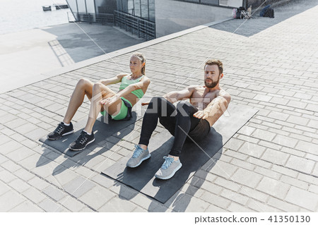 Fit fitness woman and man doing fitness exercises outdoors at city Fit fitness woman and man doing fitness exercises outdoors at city 41350130