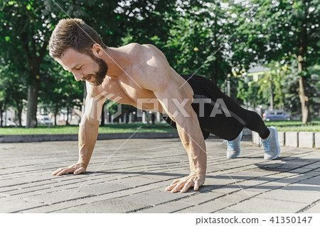 Fit fitness man doing fitness exercises outdoors at city 41350147