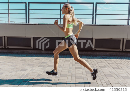 Pretty sporty woman jogging at city 41350213