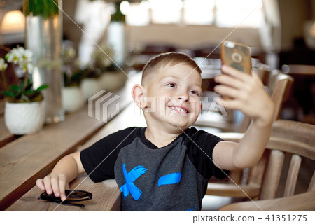 Caucasian little boy 4-5 yesrs old taking selfie in cafe 41351275