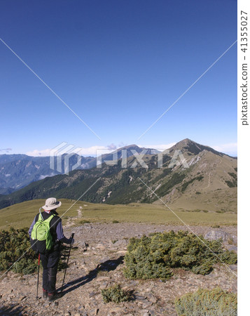 一名男性登山客走在高山上的小徑上, 天氣非常好, 可以看到清澈的藍天, 走起來非常舒適, 心情愉悅 一名男性登山客走在高山上的小徑上, 天氣非常好, 可以看到清澈的藍天, 走起來非常舒適, 心情愉悅 41355027