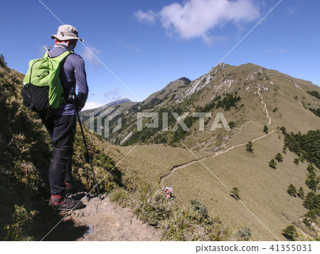 一名男性登山客走在高山上的小徑上, 天氣非常好, 可以看到清澈的藍天, 走起來非常舒適, 心情愉悅 一名男性登山客走在高山上的小徑上, 天氣非常好, 可以看到清澈的藍天, 走起來非常舒適, 心情愉悅 41355031