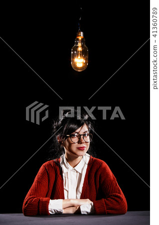 Woman sitting under the light bulb Woman sitting under the light bulb 41360789