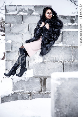 Woman sitting on a brick wall Woman sitting on a brick wall 41362012
