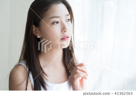 A woman sitting at a window 41362563