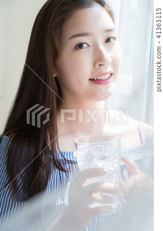 A woman standing at a window 41363115