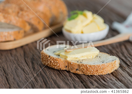 Sliced of Sesame bread with butter on wood board. 41365862
