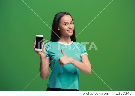 Portrait of a smiling woman showing blank smartphone screen 41367346