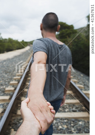men holding hands on the railroad tracks 41367631