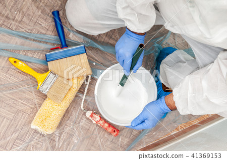 House painter at work prepares white paint House painter at work prepares white paint 41369153