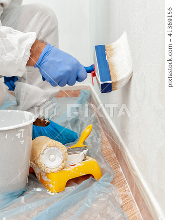 House painter at work painting a wall with a brush 41369156