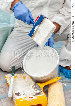 House painter at work prepares white paint 41369158