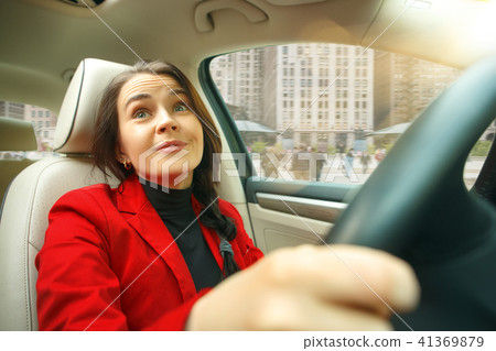 Driving around city. Young attractive woman driving a car Driving around city. Young attractive woman driving a car 41369879