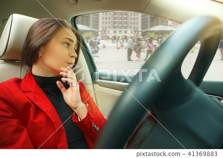 Driving around city. Young attractive woman driving a car Driving around city. Young attractive woman driving a car 41369883