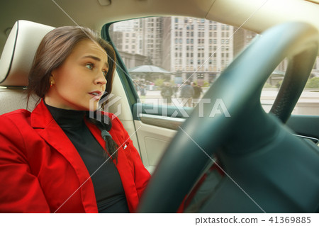 Driving around city. Young attractive woman driving a car Driving around city. Young attractive woman driving a car 41369885