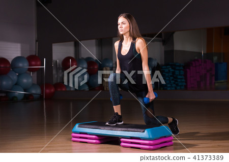 Sporty woman practice on step platform in gym Sporty woman practice on step platform in gym 41373389