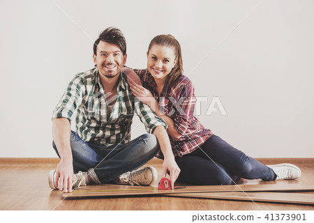 Portrait of bearded guy who measures laminate 41373901