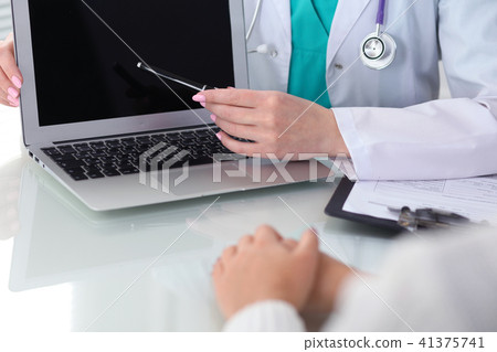 Doctor and patient, close-up.  Physician pointing into laptop computer screen. Medicine, healthcar 41375741