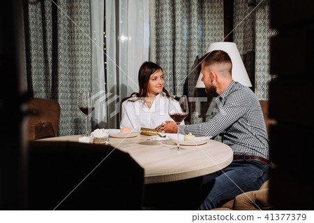 Flirting in a cafe. Beautiful loving couple sitting in a cafe enjoying in wine and conversation Flirting in a cafe. Beautiful loving couple sitting in a cafe enjoying in wine and conversation 41377379