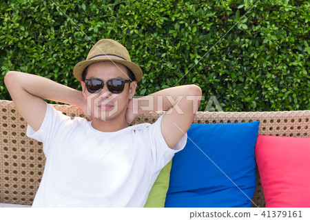 asian man relexing on vintage sofa. 41379161