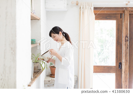 A young lady watering the potted plant 41380630