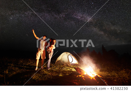 Tourist family with daughter having a rest in mountains at night under starry sky with Milky way Tourist family with daughter having a rest in mountains at night under starry sky with Milky way 41382230