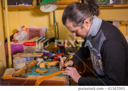 Skinner working with leather belt 41387003