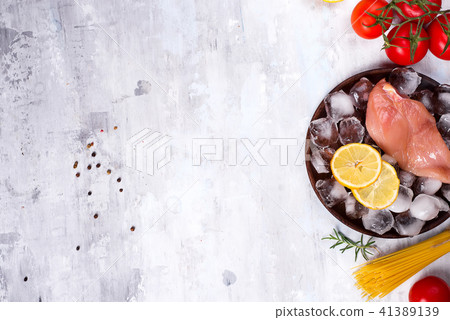 Ingredients for cooking Italian pasta with chicken and tomatoes with lemon slice and ice. Lean 41389139