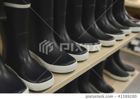 Black rubber boots on store shelves in a shop Black rubber boots on store shelves in a shop 41389280