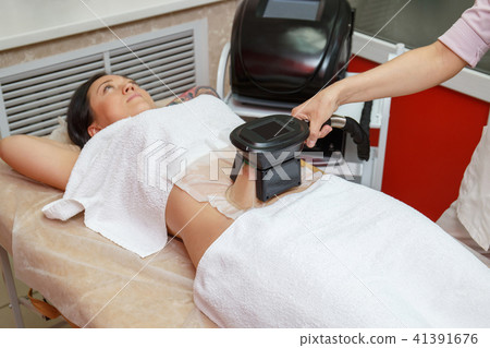 Woman getting cryolipolysis fat treatment Woman getting cryolipolysis fat treatment 41391676