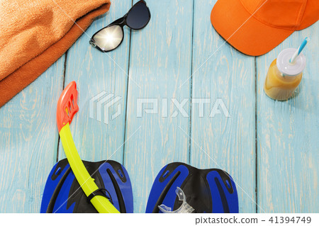 blue flippers, towel and t sunglasses on a light blue background on a Sunny day. blue flippers, towel and t sunglasses on a light blue background on a Sunny day. 41394749